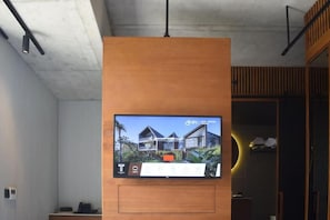 Televisio on kiinnitetty puupaneeliin, ja siitä on näkymä moderniin rakennukseen.