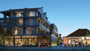 Un edificio moderno a più piani con ampie vetrate, un tetto piatto e una zona d'ingresso ben illuminata.