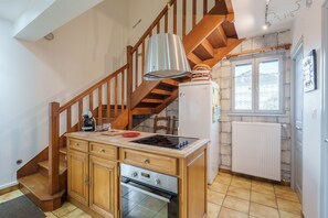 Eine Küche mit Holzausstattung, inklusive Backofen, Kühlschrank, einer Holztreppe und einem Fenster mit Blick.
