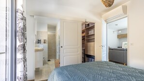 Una camera da letto con un letto, un armadio, un bagno e vista sull'esterno.