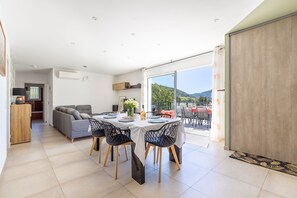 A dining area with a table, chairs, and a view of the outdoors. - Casa Olmarelli - Avec belle terrasse et jardin (Alata)