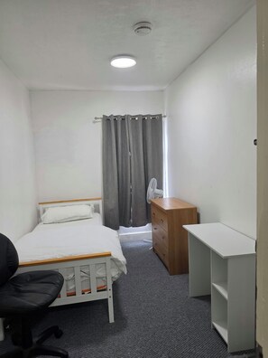 A small, clean room with a bed, a desk, a chair, a dresser, and a window with curtains. - City Centre, P/ Bathroom,room-7, 
City View Place (Cambridge)