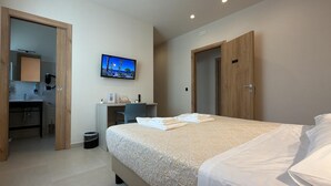 A hotel room with a bed, a desk, a TV, and a bathroom. - B&B Capo Vaticano Stay (Ricadi)