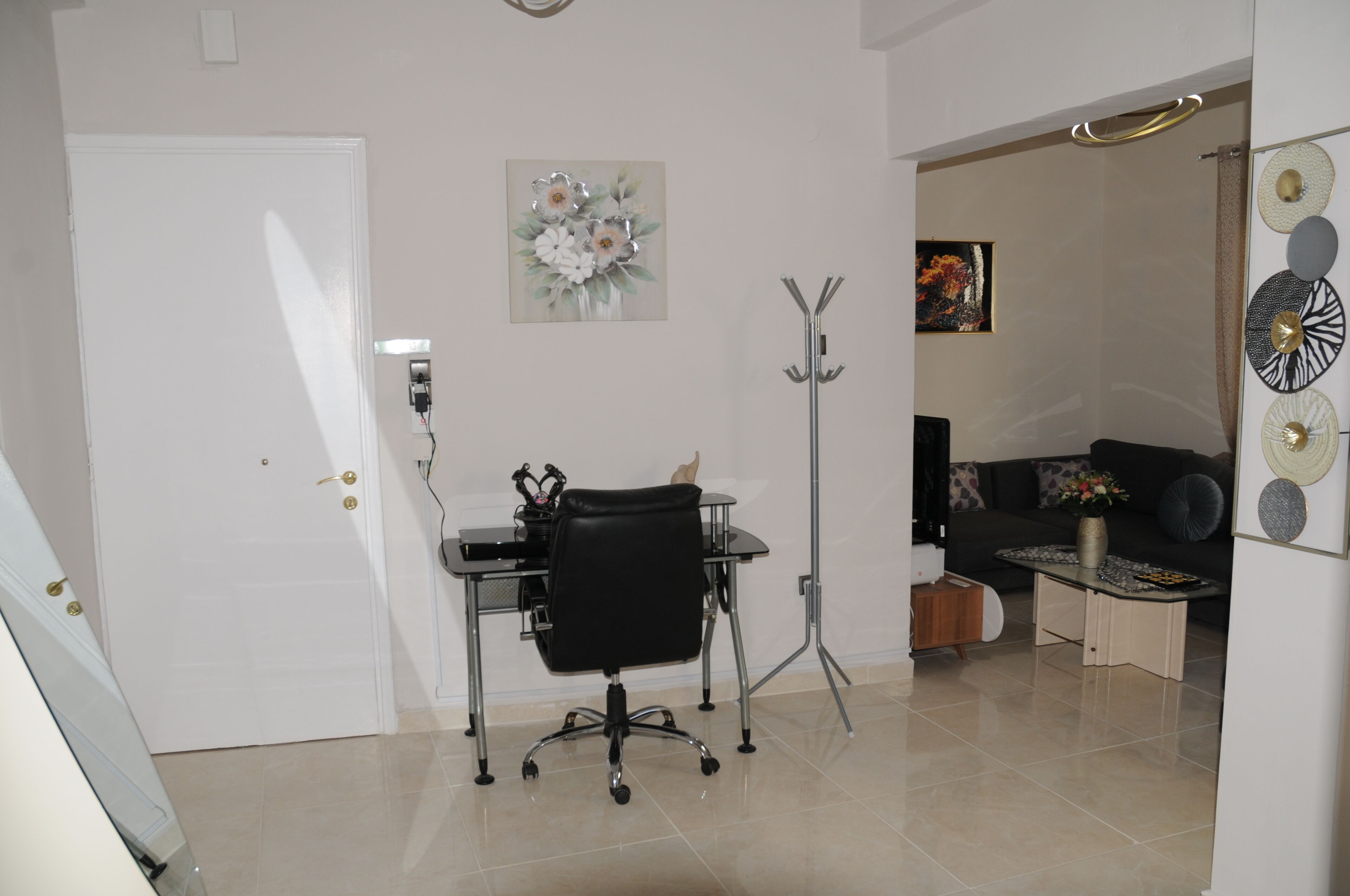Una habitación con escritorio, silla de oficina y sofá.