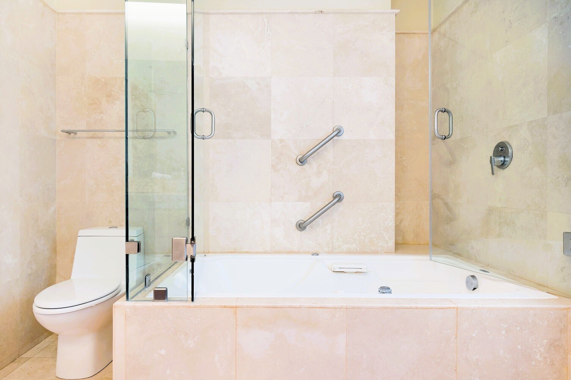 A modern bathroom with a glass-enclosed shower, a white toilet, and a bathtub.