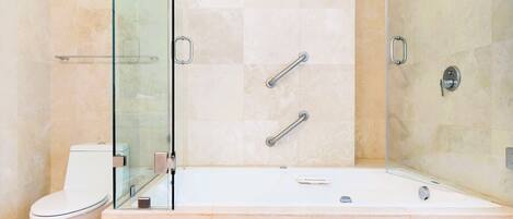 A modern bathroom with a glass-enclosed shower, a white toilet, and a bathtub.