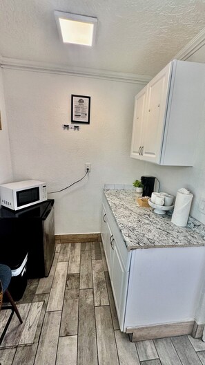 Cafetera o tetera, microondas y mesa de comedor