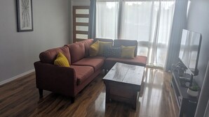A living room with a sectional sofa, a coffee table, and a TV stand.