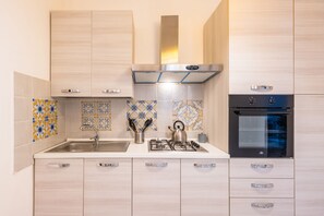 Een koelkast, een oven, een kookplaat, een koffiezetapparaat/waterkoker