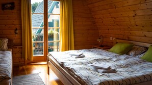 A wooden room with a bed, a nightstand, a lamp, and a window with curtains. - Three homes with pool and sauna in Gorski Kotar near Risnjak. (Crni Lug)