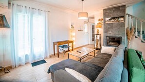 Ein Wohnzimmer mit Sofa, Couchtisch, Kamin und Essbereich mit Tisch und Stühlen.
