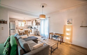 Ein modernes Wohnzimmer mit einer Couch, einem Couchtisch und einem Essbereich mit Tisch und Stühlen.