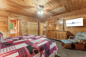 A wooden interior with a bed, dresser, chair, and a ceiling fan. - Big Cedar Area Log Cabin_Pvt Hot Tub_Serene Views&Wood Burning Fireplace_Free Attraction Tickets (Ridgedale)