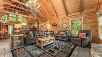 A log cabin interior with a living room, kitchen, and dining area.
