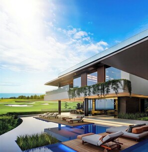Une maison moderne avec une piscine, des chaises longues et une vue sur l’océan.