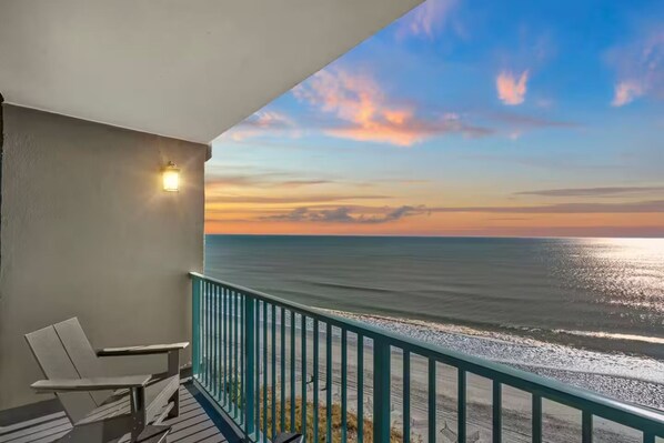 Ein Balkon mit Blick auf das Meer bei Sonnenuntergang.