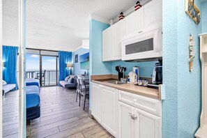 Ein gemütliches Zimmer mit Küchenzeile, Essbereich und Balkon mit Aussicht.