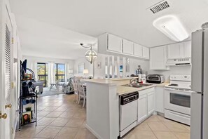 A modern kitchen with white cabinetry, a dishwasher, a stove, and a microwave. - Oceanview Oasis with Pool-Beach! (Myrtle Beach)