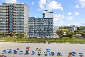 Ein Hotel mit mehreren Etagen, Balkonen und einem Poolbereich.