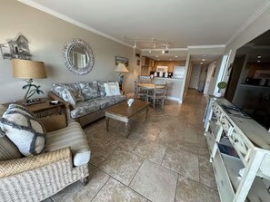 Ein Wohnzimmer mit Sofa, Couchtisch und einem Essbereich mit Stühlen.