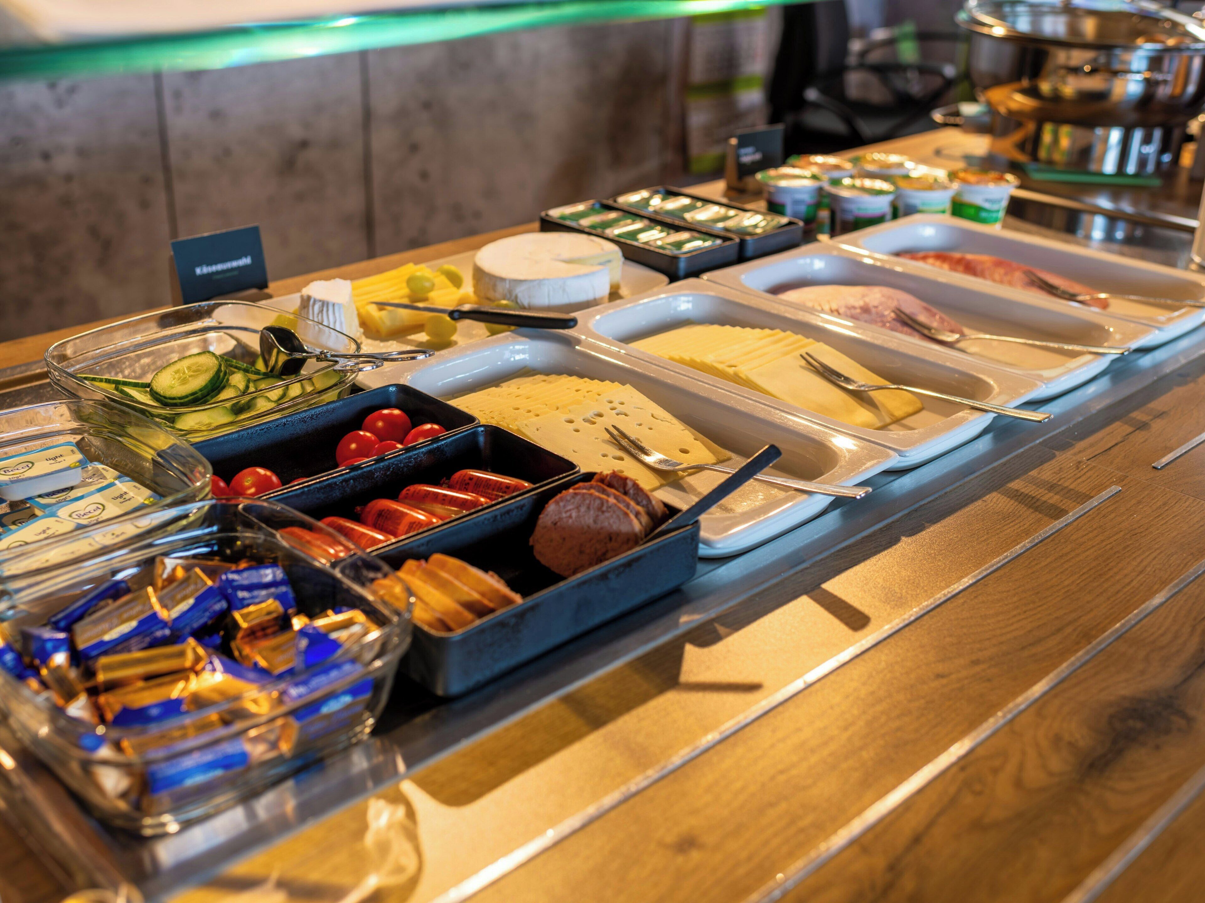 A buffet with various food items and utensils.