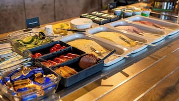 A buffet with various food items and utensils.