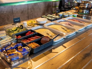 Un bufé con diversos alimentos y utensilios.