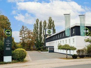 A B&B hotel with a modern facade, a parking area, and a clear sky. - B B Hotel Braunschweig West (Braunschweig)