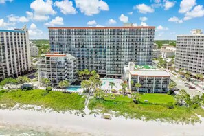 A high-rise hotel with multiple floors, a swimming pool, and surrounding greenery. - Luxury Oceanview Studio • Ground Floor Access (Myrtle Beach)