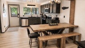Una cucina con mobili scuri, un tavolo da pranzo in legno e una panca.