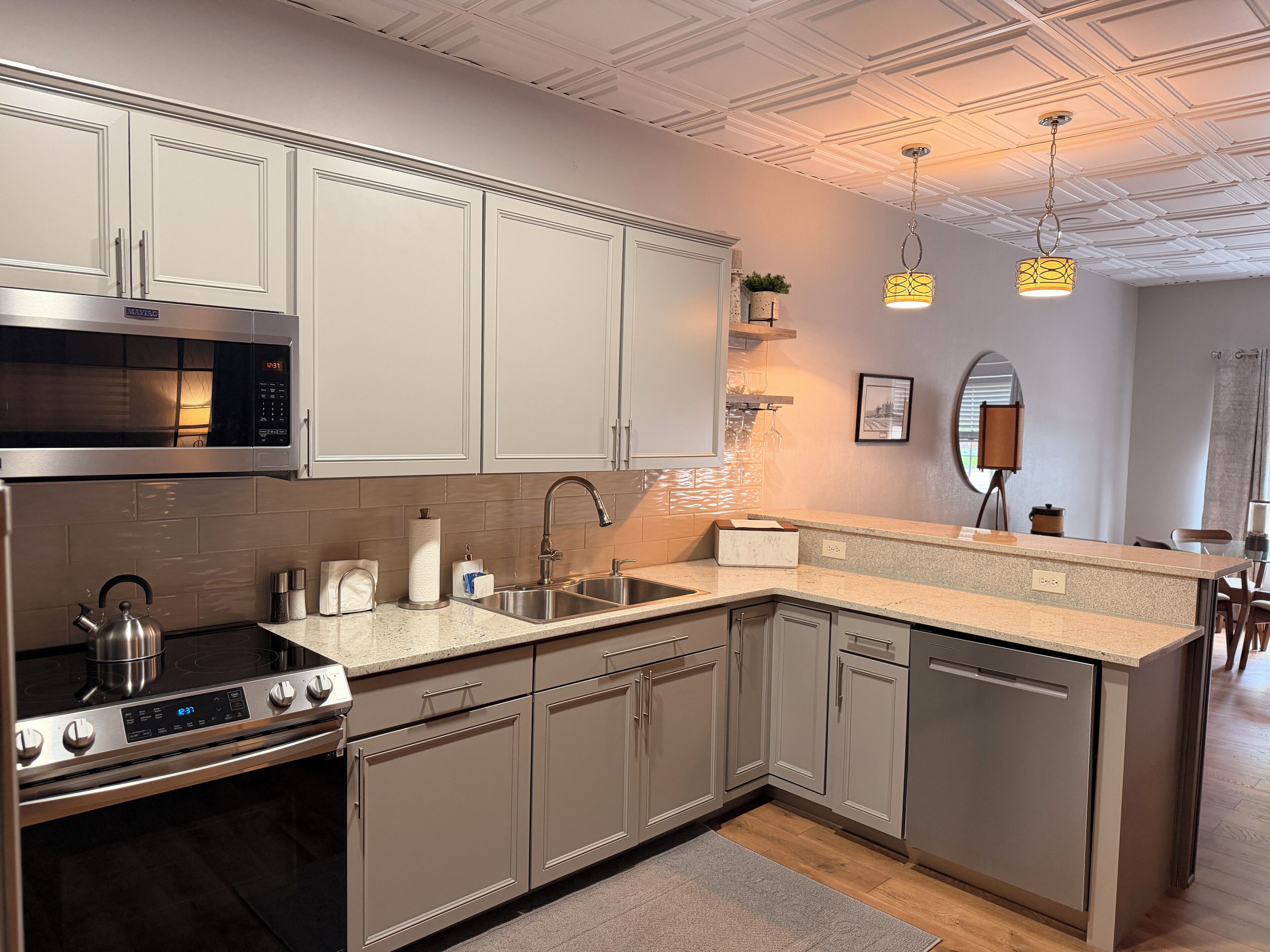 A modern kitchen with stainless steel appliances, a built-in oven, and a dishwasher.