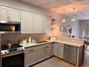 A modern kitchen with stainless steel appliances, a built-in oven, and a dishwasher.