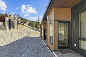 Un bâtiment moderne doté d’une façade en bois, de grandes fenêtres en verre et d’une porte en métal.