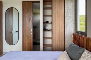 Une chambre à coucher avec un lit, une armoire en bois, un miroir et une fenêtre donnant sur un paysage agréable.