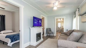 Un salon moderne avec une cheminée, un téléviseur, un canapé et un coin repas.