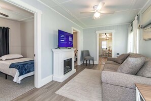 Ein modernes Wohnzimmer mit Kamin, Fernseher, Sofa und Essbereich.