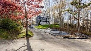 Une allée menant à une maison avec un toit en pente et un garage.