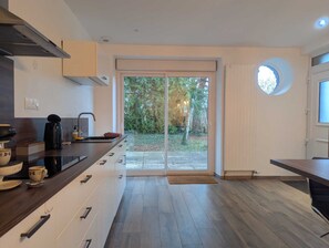 A modern kitchen with a sliding glass door leading to a garden. - Les Champs Dessus - Sarrey (Sarrey)