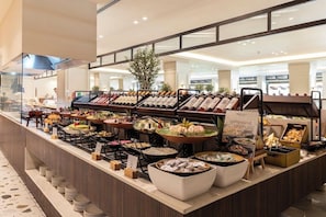 Un buffet con diversi cibi e un cartello che indica insalate miste.