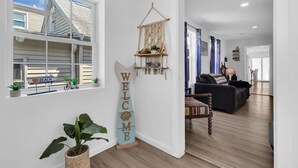 Una sala moderna con un sofá, una mesa de centro y un colgador decorativo de macramé.