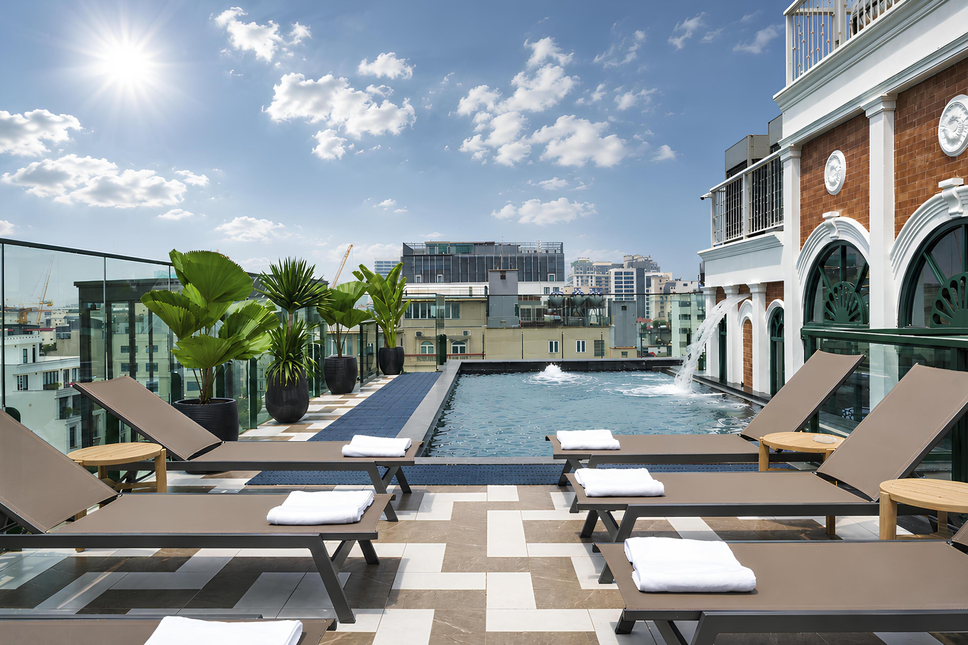 Una piscina al aire libre, sombrillas, sillones reclinables de piscina