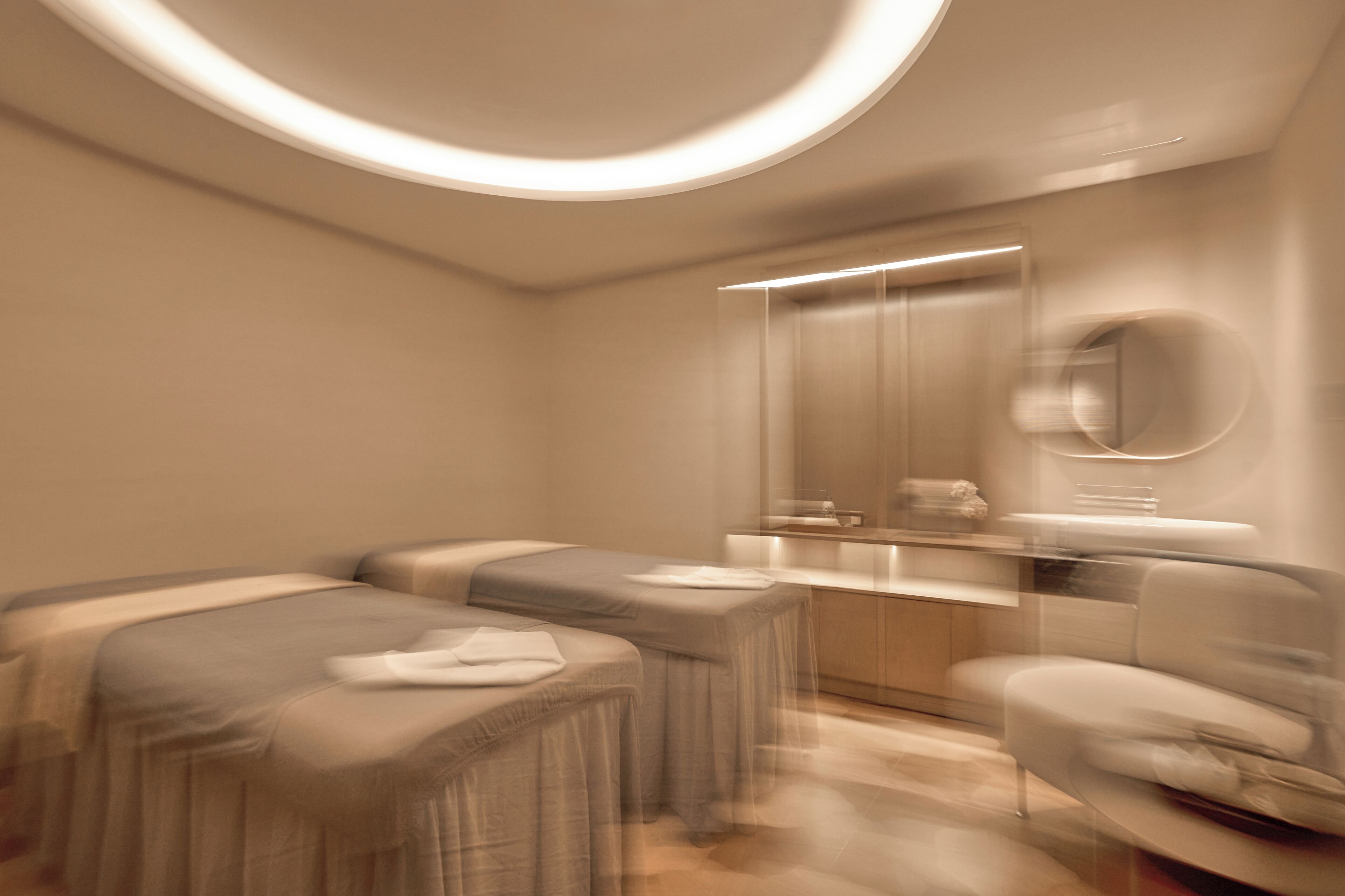 A modern bathroom with a large mirror, two benches, and a countertop.