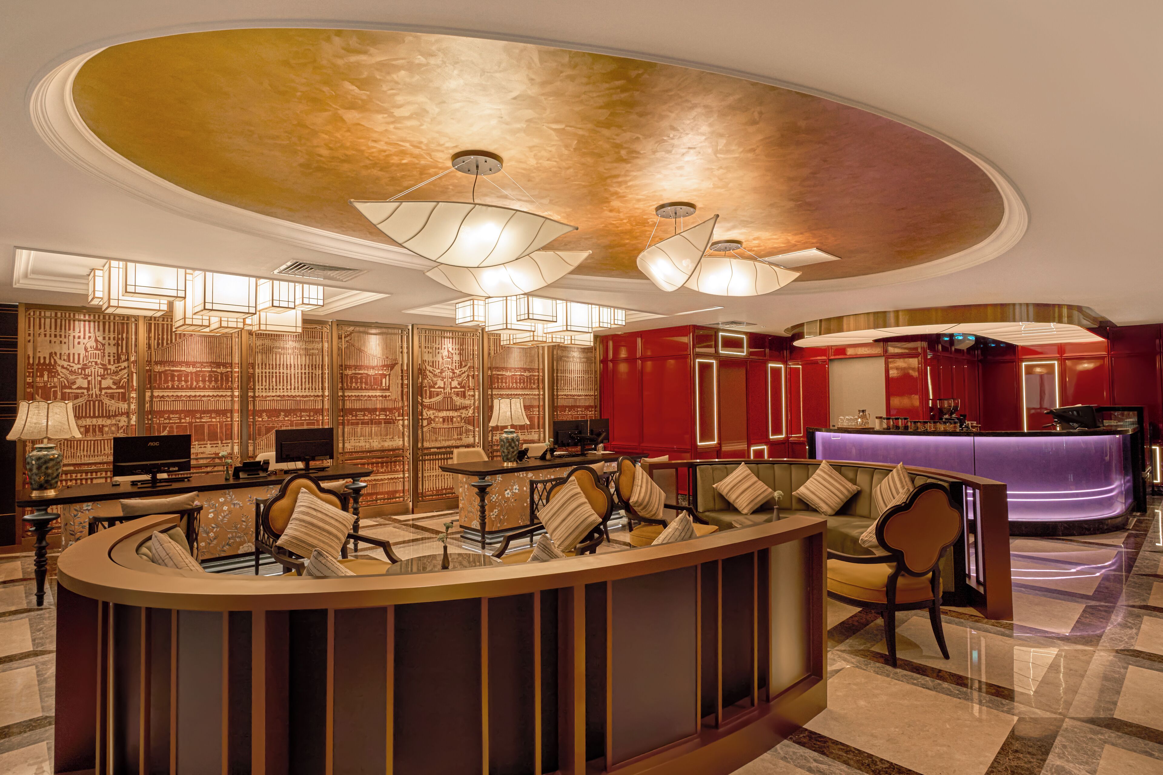 A lobby with a reception desk, seating area, and decorative wall panels.