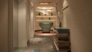 A hallway with a central seating area, a staircase, and a wall with a textured pattern. - Solaria d'Oriente Hotel (Hanoi)