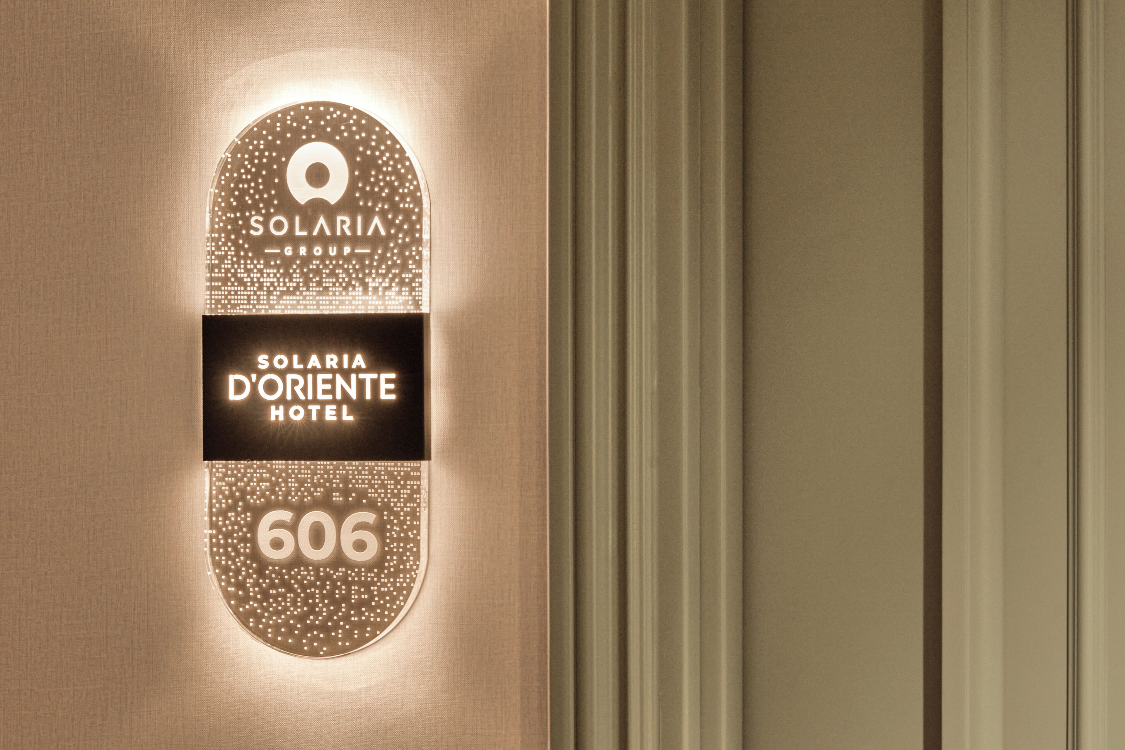 Letrero en la pared para el Hotel Solaria D'Oriente con el número 606.