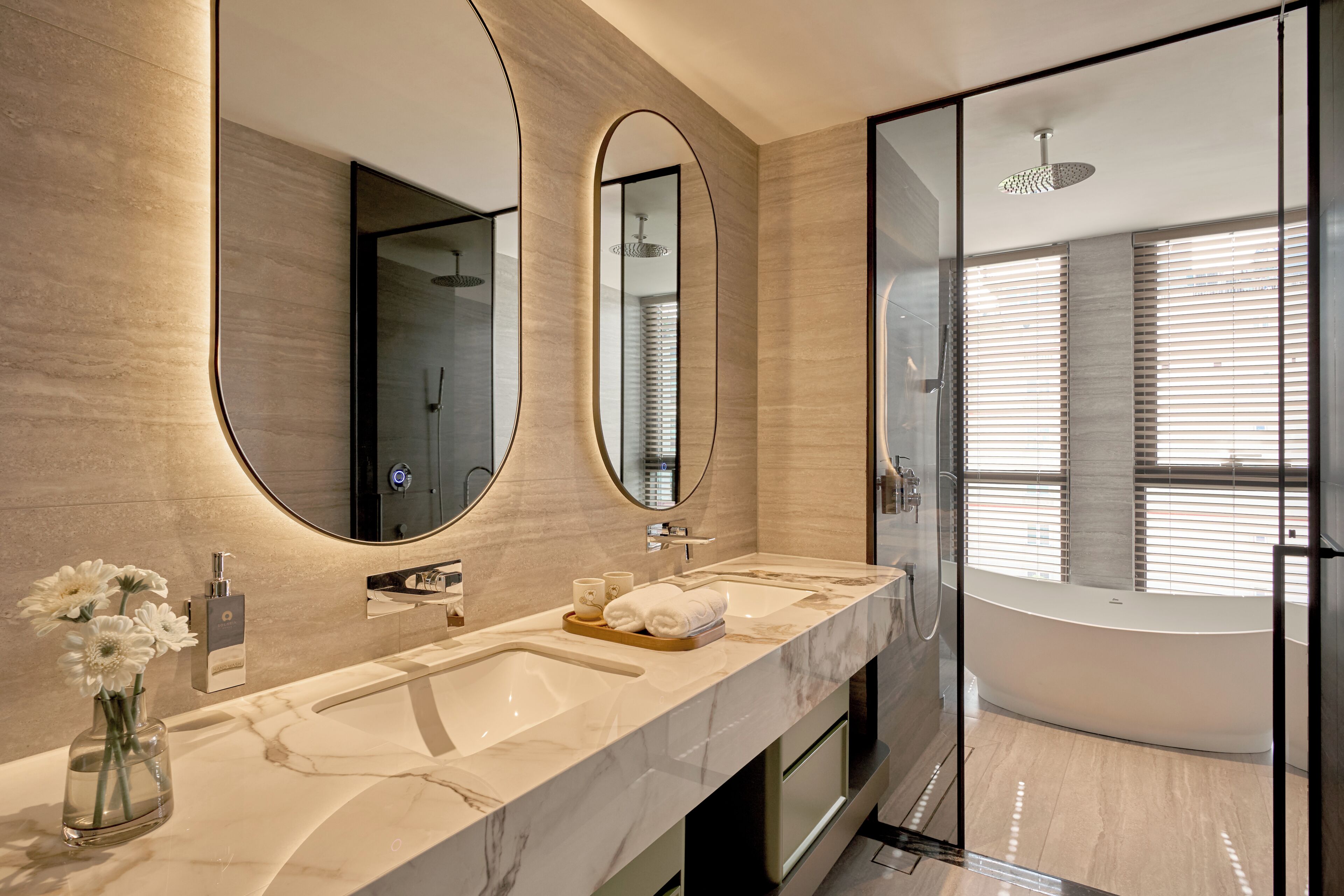 Un baño moderno con un espejo grande, dos lavamanos, una bañera y una ducha.