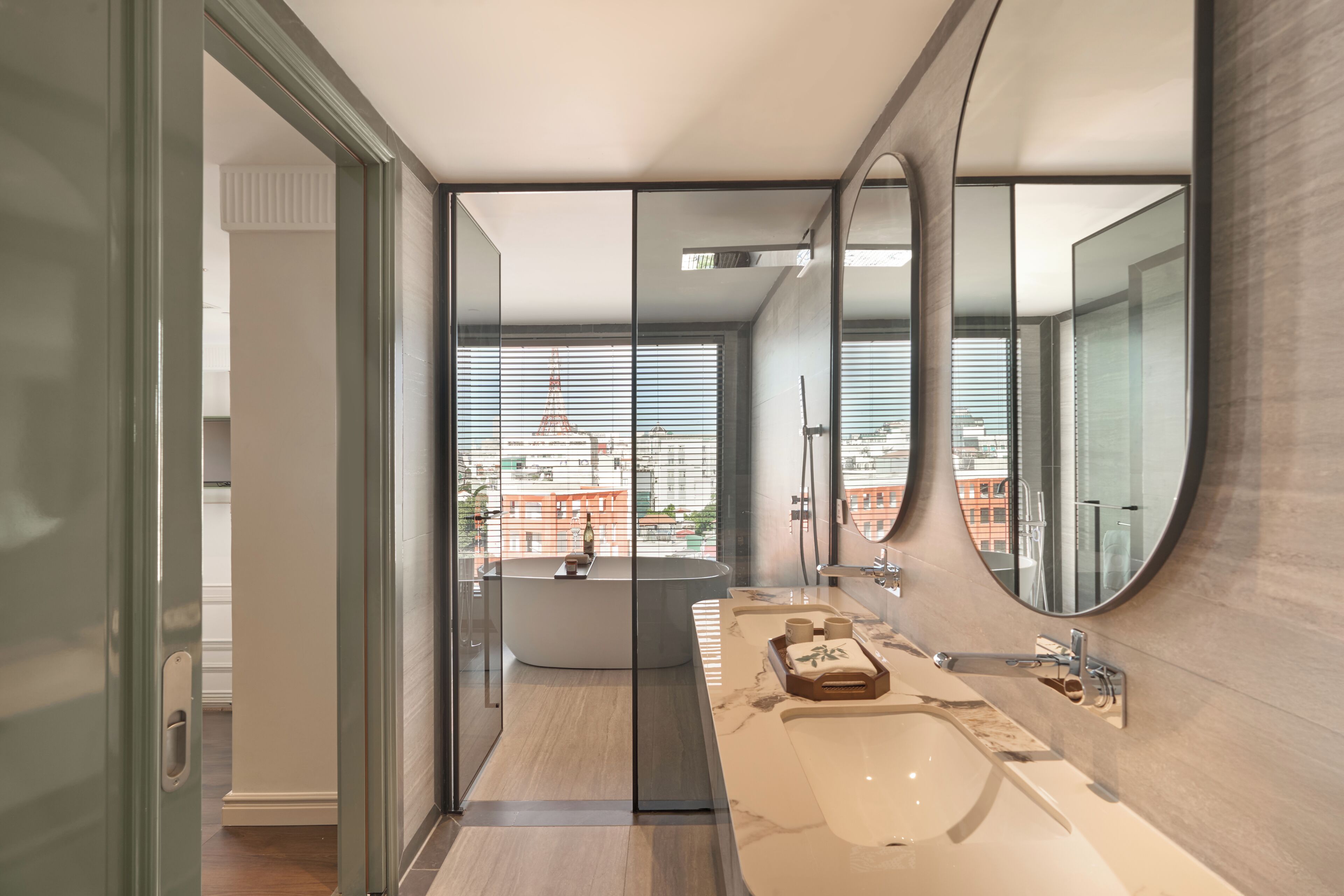 A modern bathroom with a large mirror, a bathtub, and a vanity with a sink.