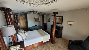 Ein Himmelbett mit Baldachin, eine Lampe, ein Telefon, ein Sofa und ein Gemälde an der Wand.