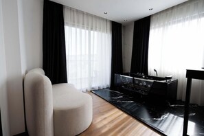 Una cocina moderna con un horno negro, una silla blanca y piso de madera.