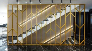 Una escalera con barandilla de diseño geométrico y moderno.